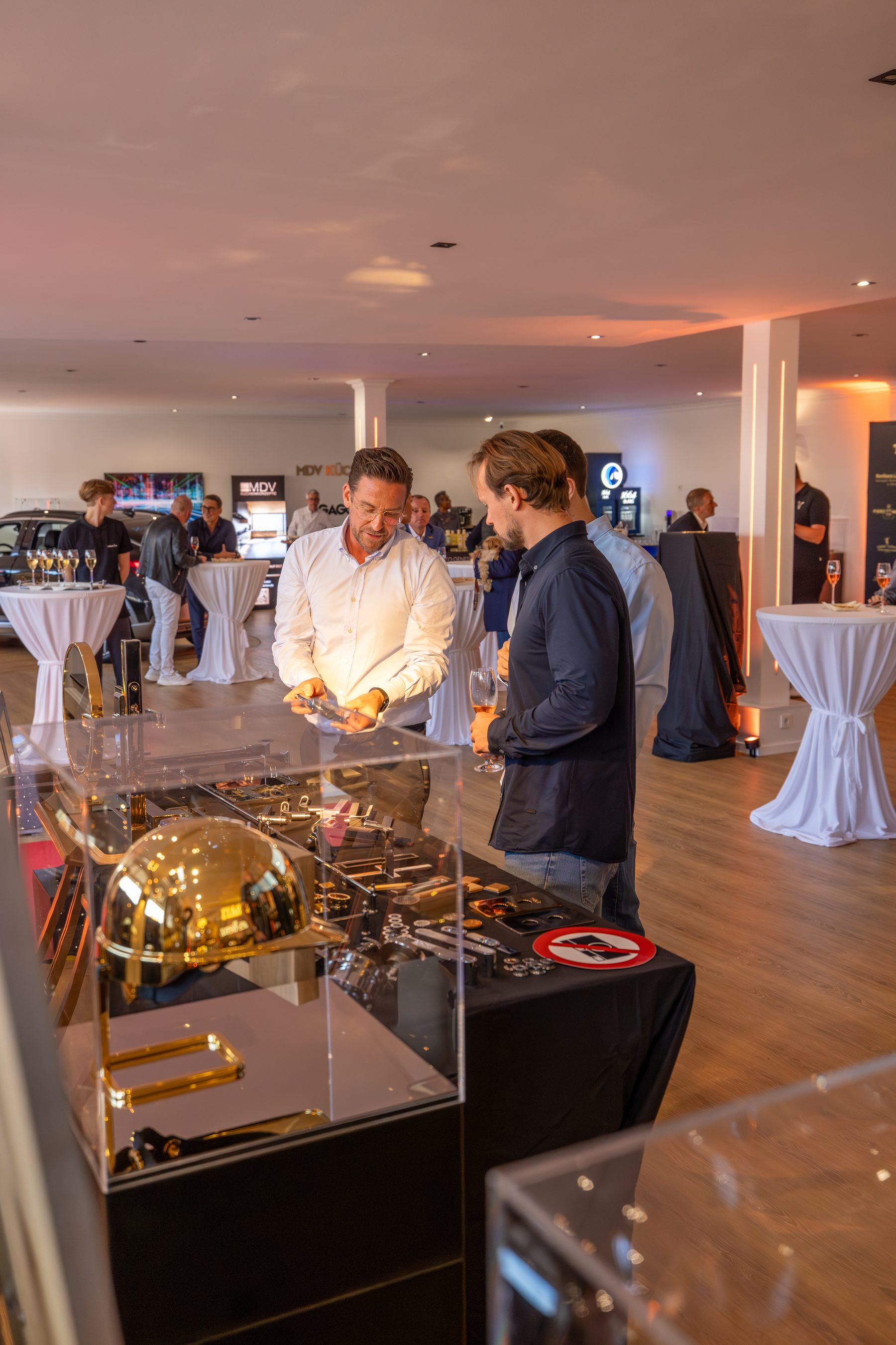 Gäste an einer Vitrine mit goldenen Exponaten im Concept Store