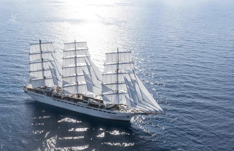 Viermaster unter vollen Segeln auf glitzernder See, aus der Luft