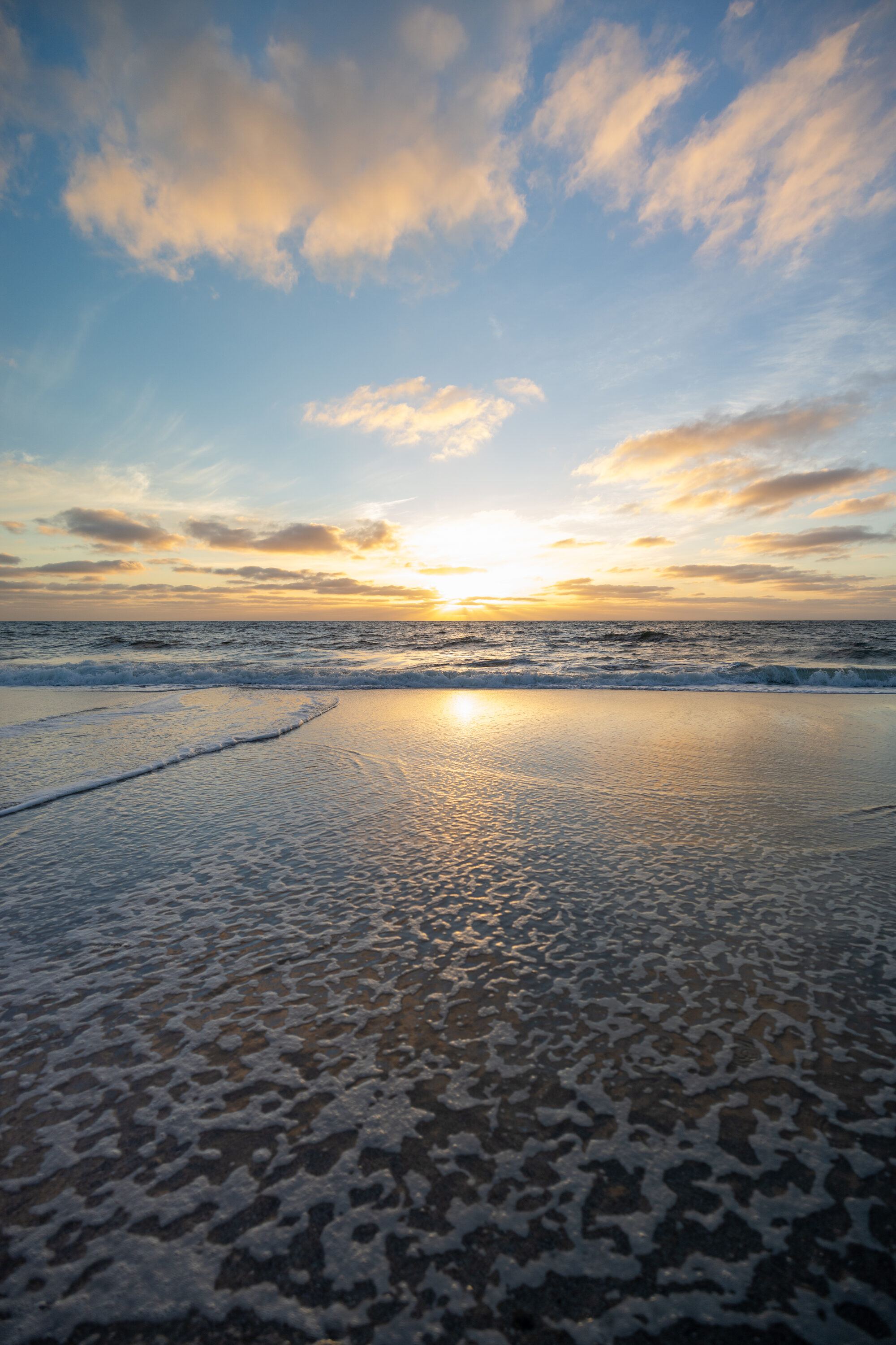 Sonnenuntergang über der Nordsee, Licht spiegelt sich im nassen Sand
